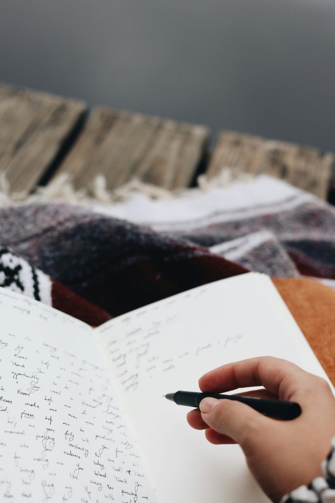 Therapeutisches Schreiben. Bildquelle: https://unsplash.com/de/fotos/person-die-auf-whitepaper-schreibt-NUQtVifTqs4